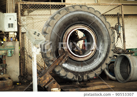 Closeup big tyre of truck under maintenance on the machine in the garage 90553307