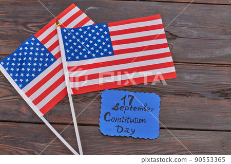 Two wave flags of the United States on woodek desk. Two wave flags of the United States on woodek desk. 90553365