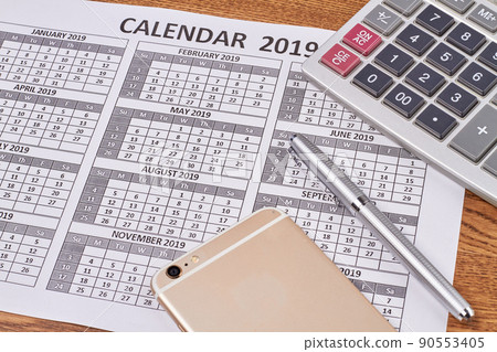 Close-up smartphone with pen and calculator on the calendar. 90553405