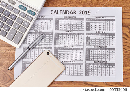 Flat lay calculator with phone and pen on the calendar. 90553406