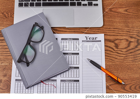 Top view flat lay year business calendar with notepad and glasses. Top view flat lay year business calendar with notepad and glasses. 90553419