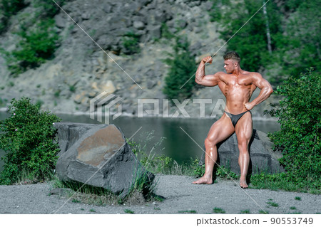 male bodybuilder by the water in nature 90553749