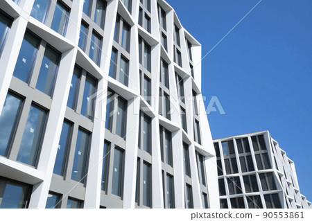 Office building extending into the blue sky, bright business building 90553861