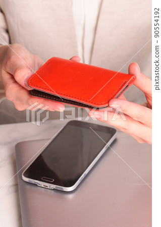 red leather cardholder in woman hands closeup photo on white wall background red leather cardholder in woman hands closeup photo on white wall background 90554192