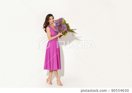 Full-length studio fashion portrait of elegant woman wearing purple dress against white wall. International womens day, Mothers day and spring concept. 90554630