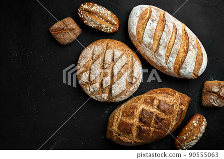 Bakery - gold rustic crusty loaves of bread and buns on black chalkboard background. 90555063