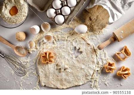 Baking concept: raw dough for biscuit, eggs, flour, cutters in the shape of star and butterfly on a white table. Top view. 90555138