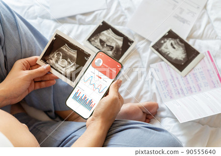 Pregnancy smartphone app. Pregnant woman holding smartphone. Mobile pregnancy online maternity application. Concept maternity, pregnancy, childbirth. Pregnancy smartphone app. Pregnant woman holding smartphone. Mobile pregnancy online maternity application. Concept maternity, pregnancy, childbirth. 90555640