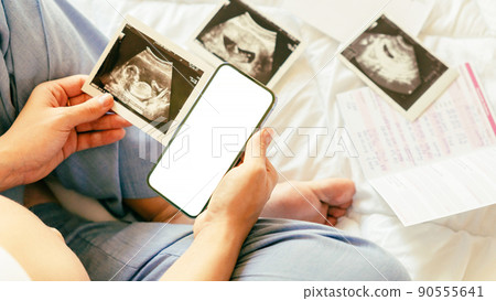 Pregnancy mockup display. Pregnant woman holding smartphone. Mobile pregnancy online maternity application mock up. Concept maternity, pregnancy, childbirth. Pregnancy mockup display. Pregnant woman holding smartphone. Mobile pregnancy online maternity application mock up. Concept maternity, pregnancy, childbirth. 90555641