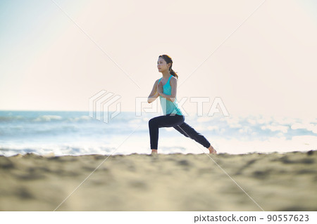 在海灘上做瑜伽的年輕女子 90557623