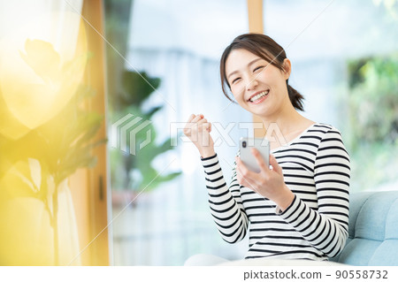 A young woman operating a smartphone A young woman operating a smartphone 90558732