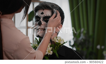 A young man is preparing makeup for Halloween. Create a Halloween look 90560422