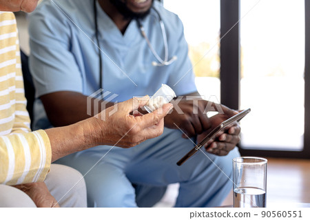 Male health worker with digital tablet discussing with caucasian senior woman over medication dose Male health worker with digital tablet discussing with caucasian senior woman over medication dose 90560551