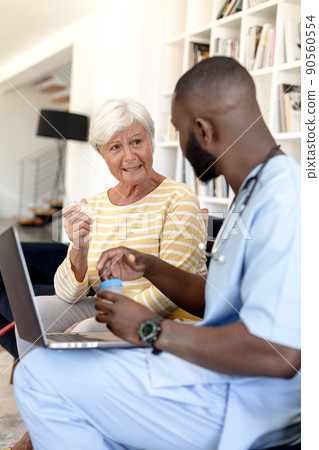 Male health worker with digital tablet discussing with caucasian senior woman over medication dose Male health worker with digital tablet discussing with caucasian senior woman over medication dose 90560554