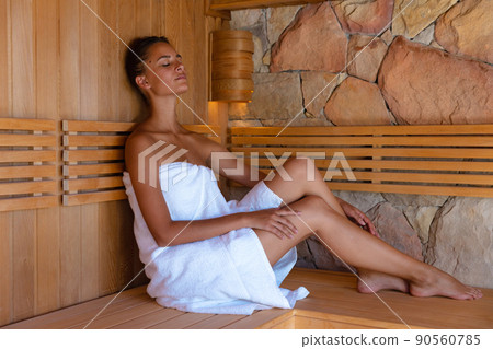 Caucasian young woman in a bathrobe relaxing in the sauna Caucasian young woman in a bathrobe relaxing in the sauna 90560785