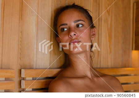 Close up of caucasian young woman in a bathrobe relaxing in the sauna 90560845