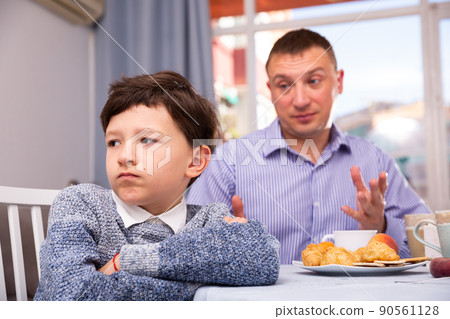 Upset father and offended son arguing in domestic interior Upset father and offended son arguing in domestic interior 90561128