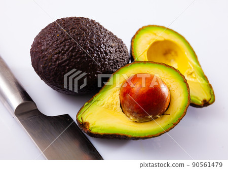 Whole and cut in half Hass avocados on white 90561479