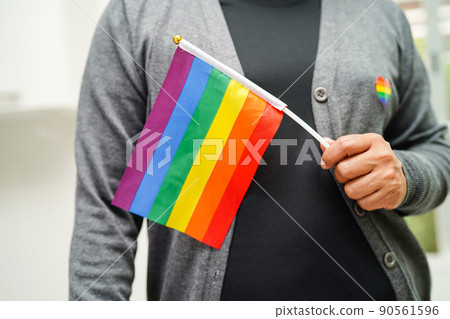 Asian woman with rainbow flag, LGBT symbol rights and gender equality, LGBT Pride Month in June. Asian woman with rainbow flag, LGBT symbol rights and gender equality, LGBT Pride Month in June. 90561596