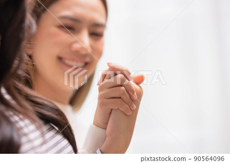 Close up hand of two female holding hands two girls sitting on bed hand by hand - same-sex lesbian couple and female friendship and love. Close up hand of two female holding hands two girls sitting on bed hand by hand - same-sex lesbian couple and female friendship and love. 90564096