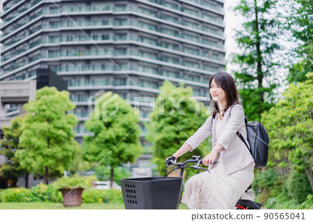 Business woman commuting on a share cycle Business woman commuting on a share cycle 90565041