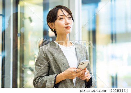 在城裡操作智能手機的女人 90565184