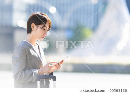 在城裡操作智能手機的女人 90565186