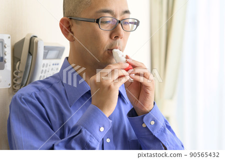 Men using asthma inhalers Men using asthma inhalers 90565432