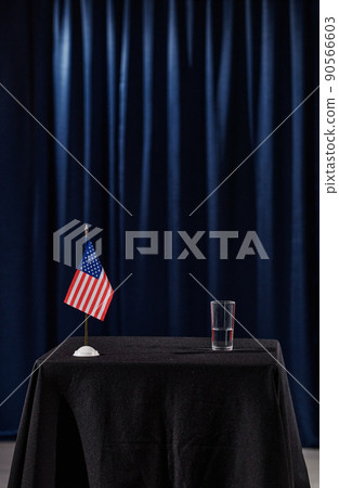 Vertical image of tribune with glass of water and American flag for speaker at conference 90566603