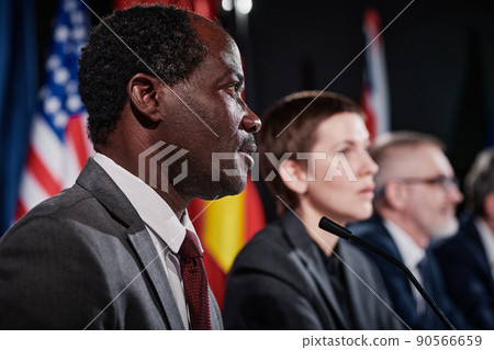 African American politician speaking to microphone while presenting his report at international conference 90566659