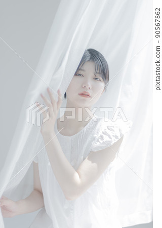 Young woman with white curtain and short hair 90567862
