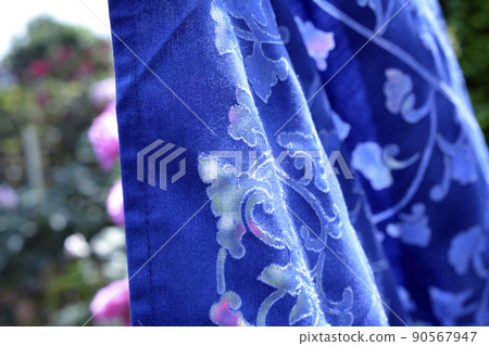 Beyond the openwork is a rose flower in full bloom. light. 90567947