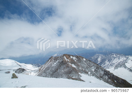 [石川/岐阜/4月]從白山山脈的山頂眺望御前峰：劍峰峰和洶湧的雲層 90575987