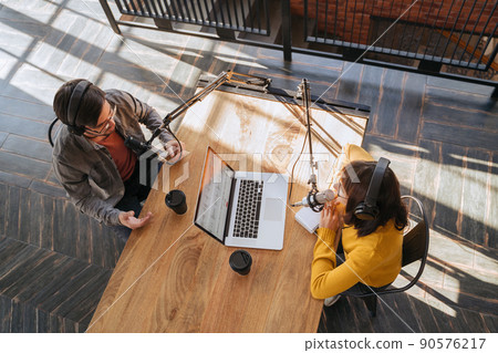 Radio host interviewing a guest in broadcast studio 90576217