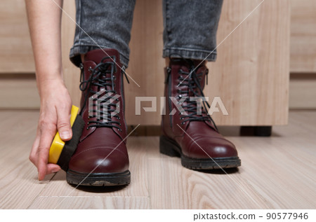Woman cleaning her own shoes 90577946