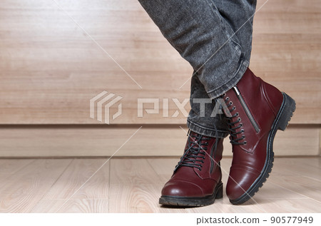 Closeup of woman legs in red leather boots and black jeans Closeup of woman legs in red leather boots and black jeans 90577949