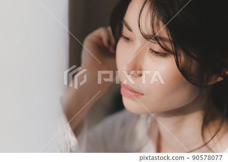 Portrait of a woman standing by the window Portrait of a woman standing by the window 90578077