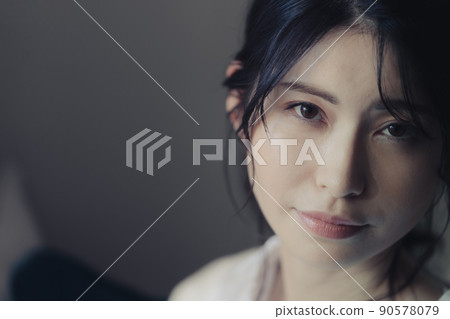 Portrait of a woman standing by the window Portrait of a woman standing by the window 90578079