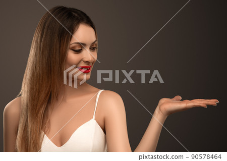 Beautiful female model presenting your product holding on her palm Beautiful female model presenting your product holding on her palm 90578464