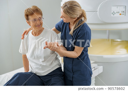 Doctor radiologist help to patient sit after procedure of MRI or CT or PET Scan in clinic Doctor radiologist help to patient sit after procedure of MRI or CT or PET Scan in clinic 90578602