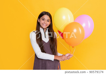 smiling girl with party colorful balloons on yellow background smiling girl with party colorful balloons on yellow background 90579174
