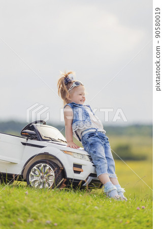 girl standing near her baby car girl standing near her baby car 90580019