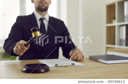 Judge gives judgment at the end of court trial and bangs gavel against sound block Judge gives judgment at the end of court trial and bangs gavel against sound block 90580612