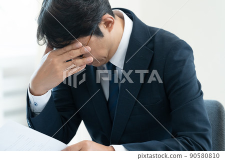 A businessman who is worried about checking documents 90580810