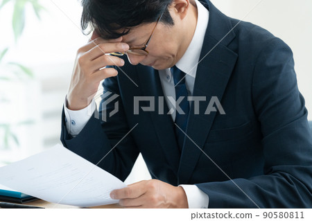 A businessman who is worried about checking documents 90580811
