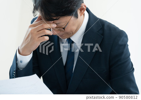 A businessman who is worried about checking documents A businessman who is worried about checking documents 90580812