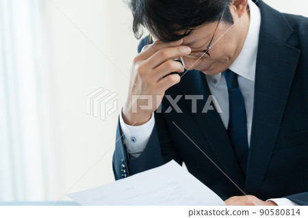 A businessman who is worried about checking documents 90580814