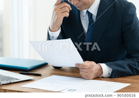 A businessman who is worried about checking documents 90580816
