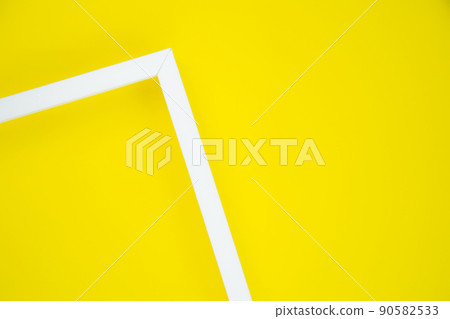 Two white wooden frame strips separate the lower left corner on a bright yellow background. High quality photo Two white wooden frame strips separate the lower left corner on a bright yellow background. High quality photo 90582533
