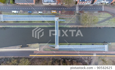 Aerial view of a walking or pedestrian bridge over a canal or river Aerial view of a walking or pedestrian bridge over a canal or river 90582625